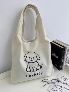 Détail du sac cabas en toile beige avec motif de chien et texture fine du tissu