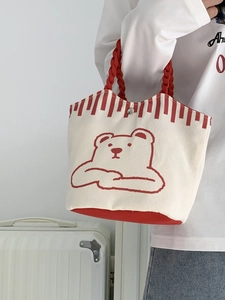 Close-up of small canvas bucket bag with cute red bear pattern and rope handles