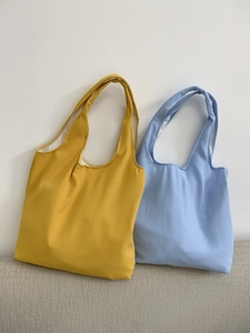 Detail of yellow and blue minimalist canvas tote bags with wide shoulder straps