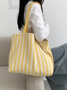 Detailed close-up of heavy-duty canvas tote bag with vibrant yellow and white vertical stripes