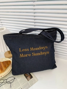 Detailed texture of dark blue denim tote bag with yellow 'More Sundays' embroidery
