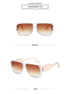 Detail of oversized double-bridge sunglasses with transparent frames and brown gradient lenses