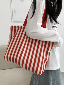 Detail of red and white striped canvas tote bag showing shoulder strap and large capacity