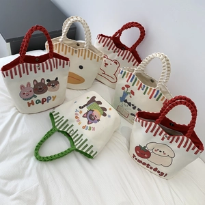 Detailed view of canvas bucket bags with cartoon animal prints and woven handles