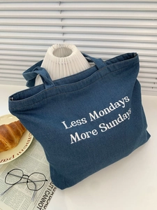 Blue denim tote bag with Less Mondays More Sundays print on a minimalist table