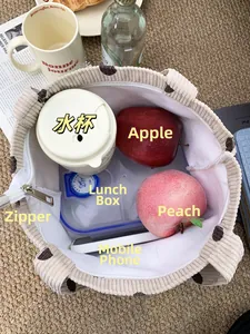 Interior view showing large capacity of corduroy tote bag with lunch box and fruits