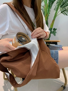 Close-up of spacious brown canvas tote bag with thick strap and large interior capacity
