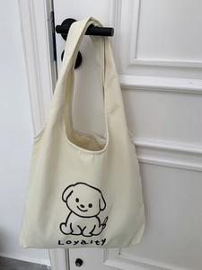 Détail d'un sac cabas en toile crème avec imprimé minimaliste de chien de dessin animé