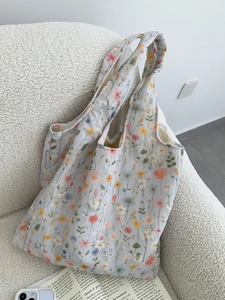 Détail de broderies florales colorées sur le tissu du sac cabas en toile bleue