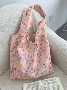 Détails de broderie florale sur un sac fourre-tout en toile rose avec doublure