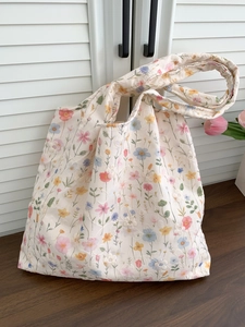Détail de la broderie florale et des motifs de fleurs sur un sac cabas en toile blanc