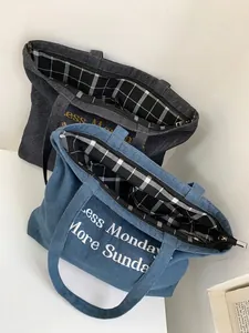 Denim tote bag with plaid lining and embroidered slogan for school or commuting