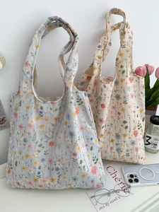 Gros plan sur la broderie florale de sacs fourre-tout en toile bleu clair et crème