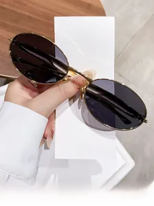Close-up of gold oval sunglasses with dark lenses and vintage metal frame details