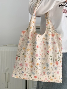 Détail de la broderie florale sur le sac cabas en toile crème aux motifs macaron