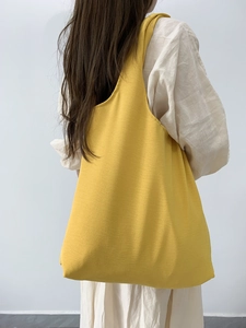 Eco-friendly bright yellow canvas tote bag shown from a minimalist rear perspective