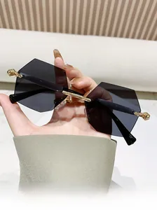Detail der randlosen geometrischen Sonnenbrille mit goldenen Bügeln und Verlaufsgläsern
