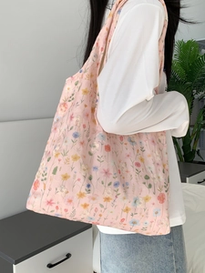 Détail porté épaule du sac cabas en toile avec broderies florales et texture souple