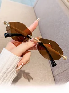 Détail de lunettes de soleil sans monture hexagonales avec verres bruns et métal doré