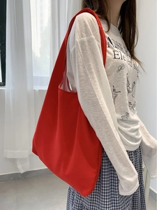 Minimalist bright red canvas tote bag for women showing a casual shoulder style