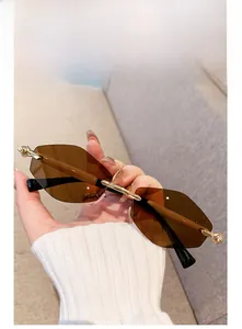 Vue détaillée des lunettes de soleil sans monture marron avec pont en métal doré