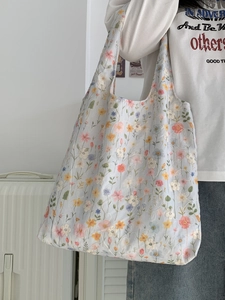 Gros plan détaillé d'un sac cabas en toile bleue avec des motifs floraux et des broderies