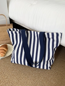 Detailed view of striped canvas tote bag in navy and white with wide blue shoulder straps