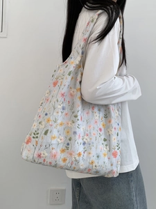 Détail de broderie florale sur un sac cabas en toile bleu clair transparent pour femme