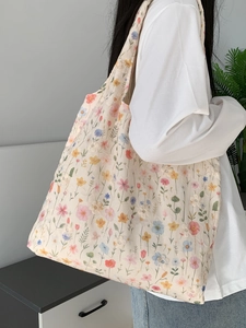 Détail du sac cabas en toile brodé de fleurs montrant la texture matelassée et le volume