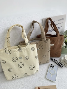 Detailed corduroy texture and smiley pattern on beige and brown tote bags