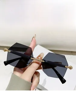Detailansicht der randlosen geometrischen Sonnenbrille mit grauen Gläsern und Goldbügeln
