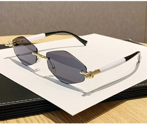 Détail de lunettes de soleil sans monture losange avec pont doré et branches bicolores