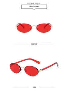 Detail of oval rimless sunglasses with gold metal frame and red tinted lenses