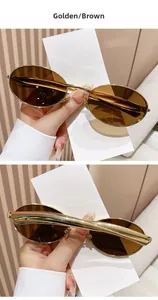 Detail view of oval metal sunglasses with bright gold frames and brown lenses