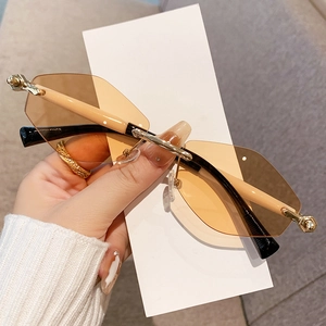 Lunettes de soleil octogonales sans monture avec verres bruns et branches dorées