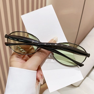 Chic oval sunglasses with light green lenses and elegant gold chain metal temples