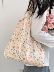 Détail de la broderie florale sur un sac fourre-tout en toile beige à longues anses