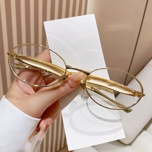 Fashionable oval metal frame sunglasses with vintage gold finish and clear lenses