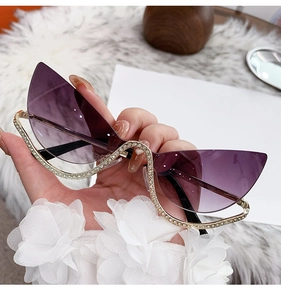Détail de lunettes de soleil œil-de-chat sans monture avec strass et verres dégradés violets