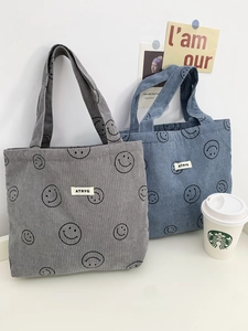 Close-up of corduroy tote bags with smiley patterns in blue and gray colors