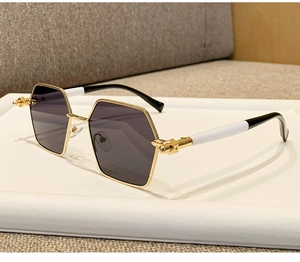 Macro detail of hexagonal gold metal frame sunglasses with gray lenses and rivet hinges