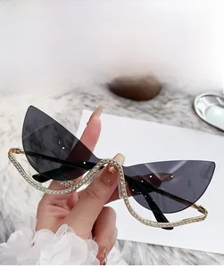 Détail de lunettes de soleil œil-de-chat grises avec strass de luxe sur verres sans monture