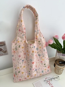 Détail du sac cabas en toile à fleurs roses avec anses à volants et broderies fines