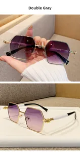 Detail of hexagonal gold metal frames with double gray gradient lenses and sleek temples