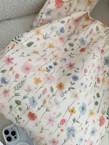 Gros plan de la broderie florale et de l'imprimé fleuri sur le sac en toile crème