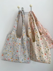 Détail du sac cabas en toile avec broderie florale et motifs de fleurs des champs pastels