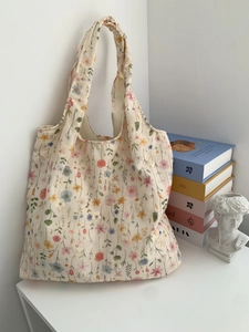 Détail d'une broderie florale sur un sac fourre-tout en toile crème au style doux