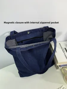 Macro view of denim tote bag showing magnetic snap closure and internal zipper pocket