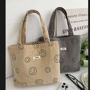 Detailed corduroy texture of khaki and gray tote bags with smiling face print