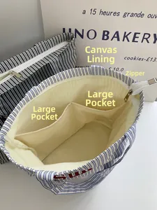 Détail du cabas en toile rayée montrant la doublure intérieure et la fermeture éclair
